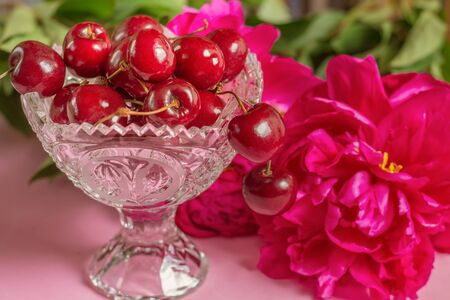 Cherries in the beautiful crystal vase with peonyの写真素材