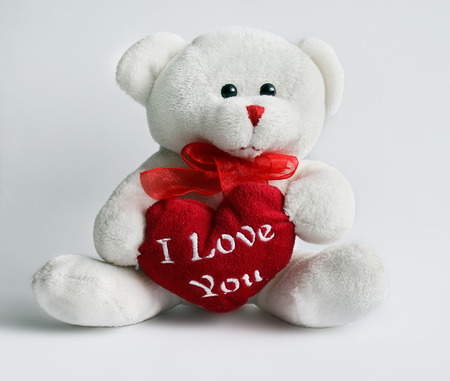 white teddy bear with a red heart on a white backgroundの写真素材