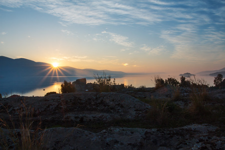 Magic view of the setting sun over the sea, the cliffs, mountains.の写真素材