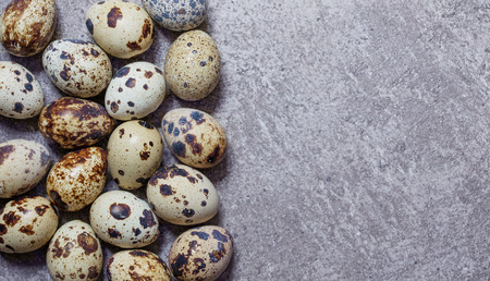 some fresh eggs of quail on the stone backgroundの写真素材