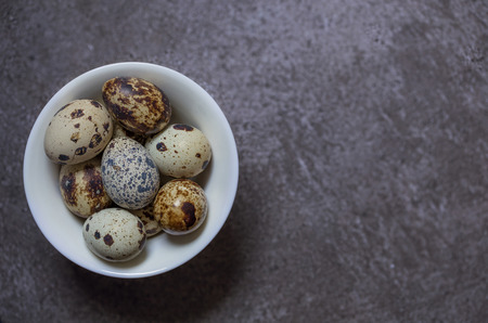 some fresh eggs of quail on the stone backgroundの写真素材