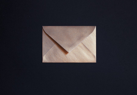 Closed golden envelope on black backgroundの写真素材