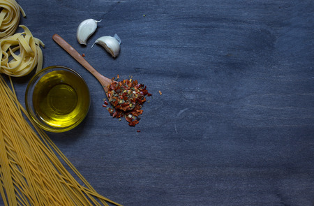 Pasta with olive oil and condiment on dark backgroundの写真素材