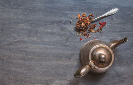 Antique teapot and strawberry tea on dark wooden background. Top viewの写真素材