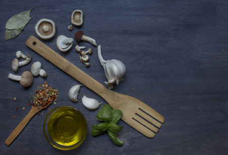 Mushrooms, condiment and wooden equipments on dark backgroundの写真素材