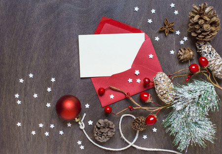 Christmas background with red envelope, invitation card, decoration and sugar stars on wooden background. Top viewの写真素材