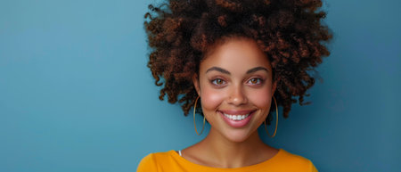 On a blue background, standing alone, a young smiling happy pretty latin woman is holding a mobile...