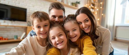 The happy mother is taking a family selfie while the husband and children look at her smartphone, while playful adopted children are posing for a funny picture and smiling at her and her husband,の素材