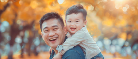 Young Asian father and enjoying son nature outdoors in a park while carrying their son on their backsの素材