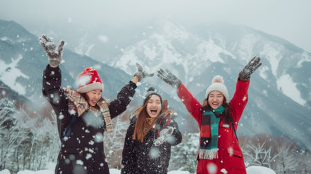 In the winter time concept, three happy adult girls throw the first snow on the background of mountains.の素材