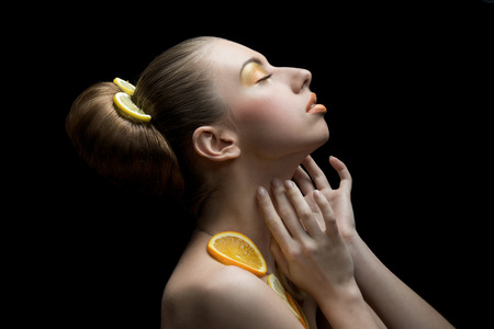Woman with orange lemon fruit isolated on a blackの写真素材