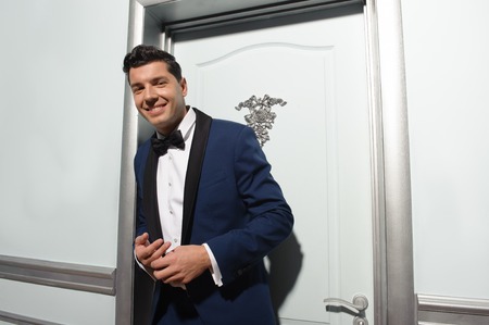 Half length portrait of handsome business leader looking at camera on room interior background. Low angle.の写真素材