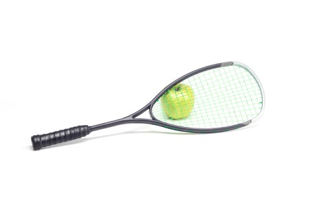 Green apple behind sport racket isolated on whiteの写真素材