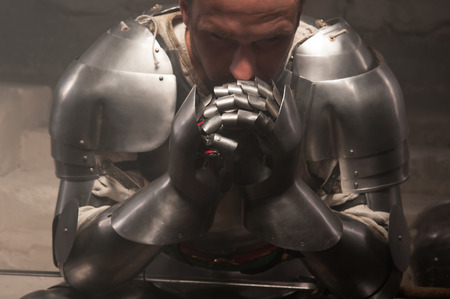 Closeup portrait of medieval knight armor glove holding sword, dark backgroundの写真素材