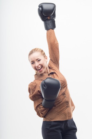 Young attractive business woman with boxing gloves celebrating win, isolated on white backgroundの写真素材