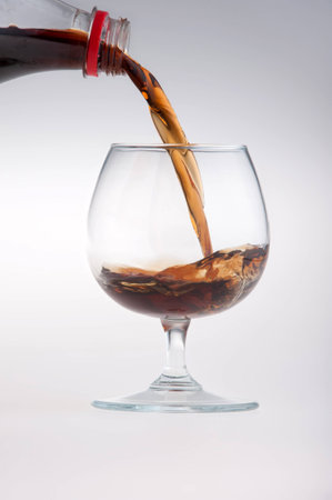 Glass being filled with cola isolated on white backgroundの写真素材