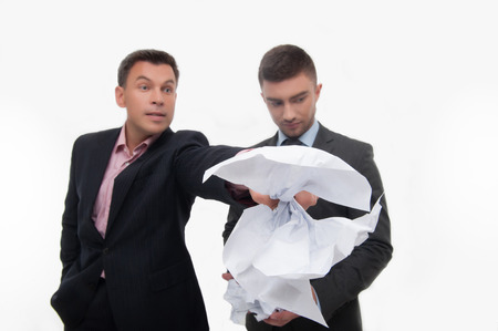 Senior and junior business people  Boss angry with employee looking down, holding crumpled paper selected focus, isolated on whiteの写真素材