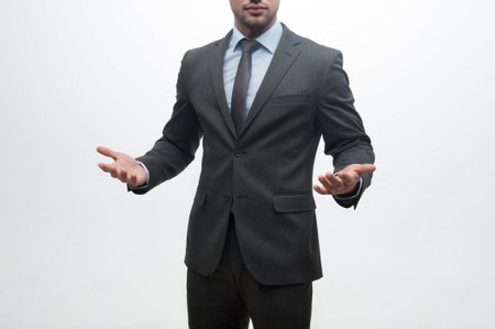 Closeup portrait of young handsome businessman in suit raising hands isolated on whiteの写真素材