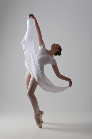 Full length portrait of young and beautiful modern style ballet dancer posing isolated on grey background, studio shotの写真素材
