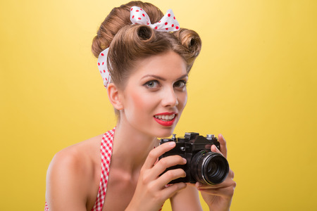 Half length portrait of beautiful sexy girl with pretty smile wearing dress in pin-up style posing...