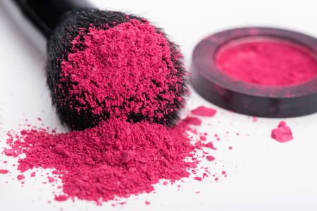 Close-up of  natural  black bristle of professional  make-up brush with crashed pink eyeshadow lying near opened single pink eyeshadow  pot  isolated on white backgroundの写真素材