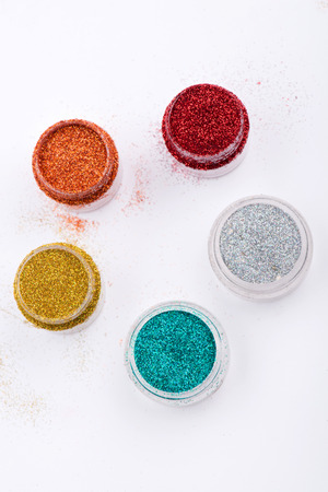 Close-up top view of  powder eyeshadows  in red, orange blue silver and yellow colours isolated on white background with copy placeの写真素材