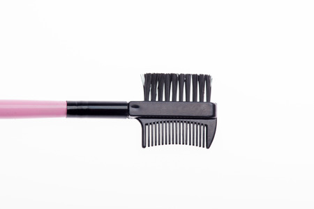 Close-up side view of black brush for eyebrows with pink handle  and black ferrule isolated on white backgroundの写真素材