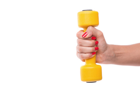Woman with nice red polished nails holding yellow dumbbell in her arm showing us her strength. Isolated on white backgroundの写真素材