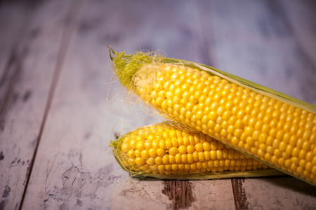 Great yellow corn lying on the wooden table is lure for everyone
