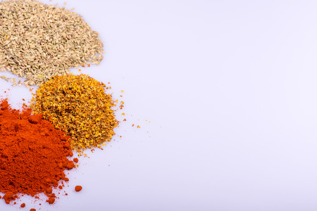 Composition of  various ground  different colorful  spices heaps like paprika oregano  cardamom  isolated on white background with copy spaceの写真素材