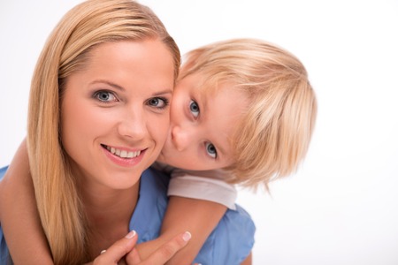Happy family of mother holding son  on her back kissing mum  smiling looking  at camera  isolated on white background  waist upの写真素材