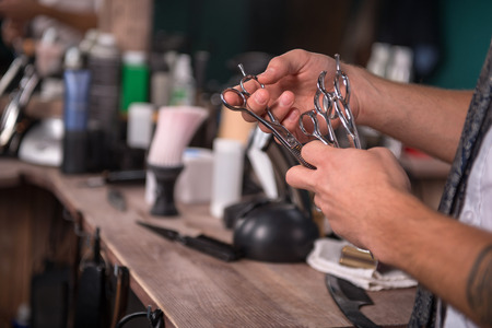 hairdresser  holding many pairs of scissors in in  professional  hairdressing salon   with selective focusの写真素材