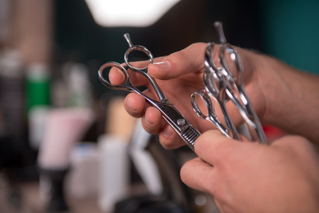 hairdresser  holding many pairs of scissors in in  professional  hairdressing salon   with selective focusの写真素材