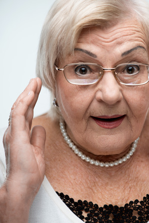Curious granny looking at cameraの写真素材