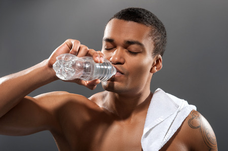 Young Africana sportsman drinking water after workoutの写真素材