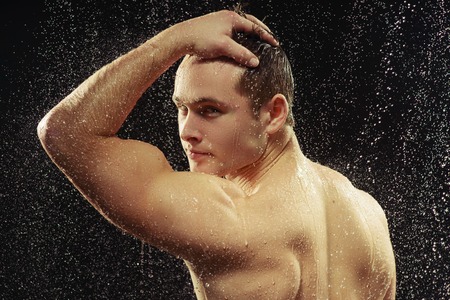 Handsome young man taking a shower
