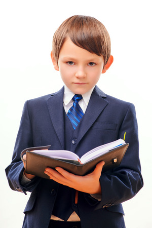 Business child in suit and tie posing with notepadの写真素材