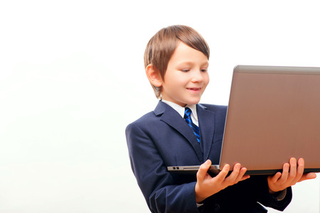 Business child in suit and tie posing with laptopの写真素材