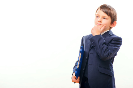 Business child in suit and tie posing with a clipboardの写真素材
