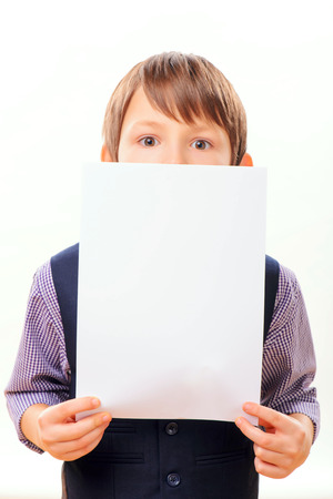 Smart child posing with a blank sheet of paperの写真素材