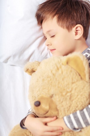 Portrait of a boy sleeping with teddy bearの写真素材