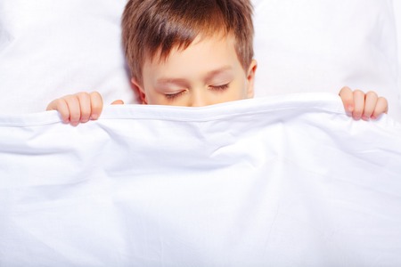 Portrait of a boy sleeping under the blanketの写真素材