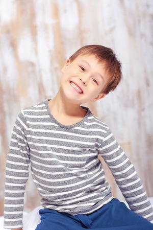 Portrait of a cute emotional little boy in bedの写真素材