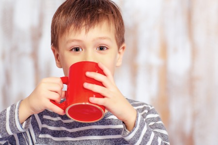 Portrait of little boy with a cupの写真素材