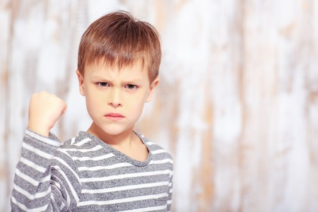 Portrait of a cute emotional little boy in bedの写真素材