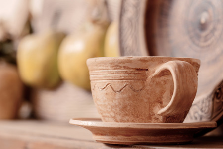 Beautiful ceramic cup. Close-up with selective focus on a ceramic cup standing on a shelf in clay studioの写真素材