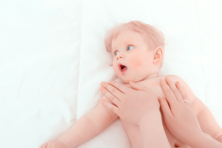 Massage.  Little baby having a massage from his mother with a big pleasureの写真素材