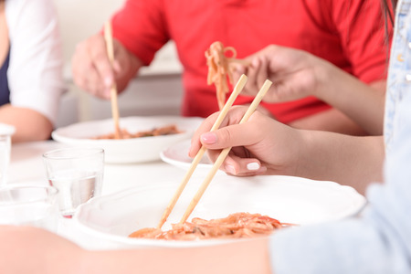 So easy. Close-up of Asians eating with sticksの写真素材