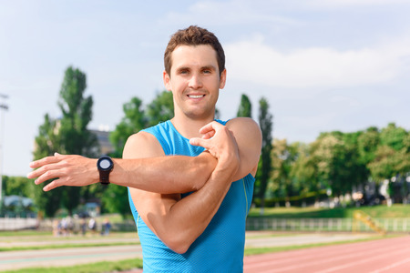 Stretch your body. Attractive young man standing and stretching his arms.の写真素材