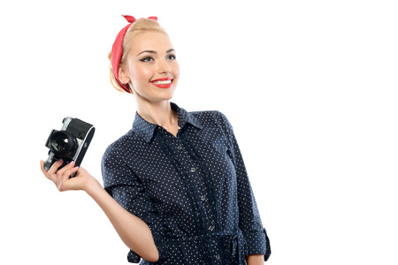 Portrait of a beautiful blond pin up girl with ponytail and red bandana wearing a blue dotted dress...